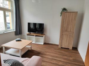 a living room with a flat screen tv and a table at FeWo Bismarck 29 in Stendal