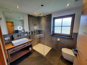 een badkamer met een wastafel, een douche en een toilet bij Appartements Hochödlehen in Schönau am Königssee