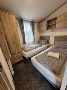 um pequeno quarto com 2 camas e uma janela em Dee Lodge em Boat of Garten