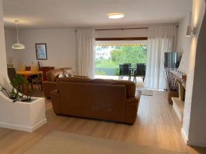 a living room with a brown couch and a dining room at Casa Anemone in Denia