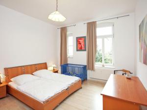 um quarto com uma cama, uma secretária e uma janela em Alluring Villa in Grunhainichen Borstendorf with Garden em Leubsdorf