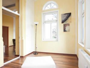 ein Wohnzimmer mit einem weißen Sofa und einem Fenster in der Unterkunft Alluring Villa in Grunhainichen Borstendorf with Garden in Leubsdorf