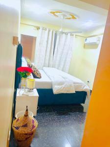 een slaapkamer met een bed en een tafel met een mand bij The central Heartbeat Haven Intercity in Dar es Salaam