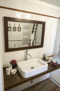 a bathroom with a white sink and a mirror at La Casa del Fabbro in Troina