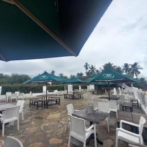 a patio with tables and chairs and umbrellas at The Beach House by Maasai in Mombasa