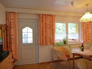 ein Esszimmer mit orangefarbenen Vorhängen und einer Tür in der Unterkunft Luxurious Apartment in Heubach Germany in the Forest in Fehrenbach