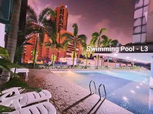 een zwembad met palmbomen en gebouwen bij Taragon Apartment - KL in Kuala Lumpur