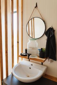 een badkamer met een wastafel en een spiegel op een tafel bij Sidehill - zážitkové ubytovanie v prírode in Martin