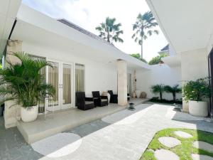 a living room with a couch and chairs and palm trees at Apple Villas & Apartments in Kerobokan