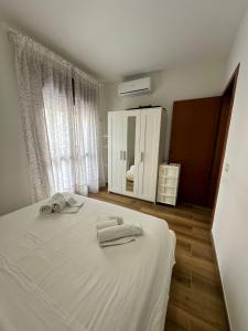 Un dormitorio con una cama blanca con toallas. en Casa di Azzurra, en Sciacca