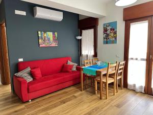 sala de estar con sofá rojo y mesa en Casa di Azzurra, en Sciacca