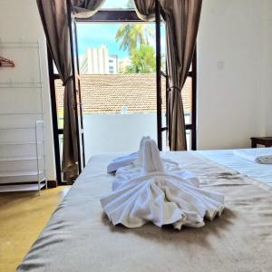 a bed with a white towel on top of it at Mamma Mia Villa and Cafeteria in Unawatuna +19 photos