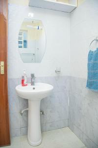 uma casa de banho com um lavatório branco e um espelho. em One Bedroom, Lake View with GYM em Nakuru