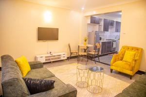 uma sala de estar com um sofá e cadeiras e uma televisão em One Bedroom, Lake View with GYM em Nakuru