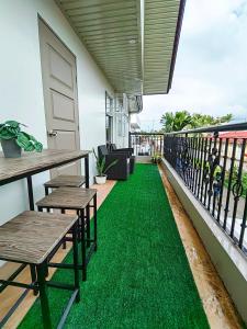 a balcony with green grass and two tables and a door at HOST HOMESPACE in Tacloban
