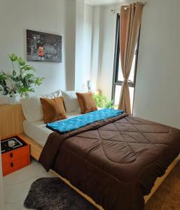 a bedroom with a bed and a window at Airhub Hostel Phuket Airport in Ban Bo Han
