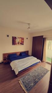 1 dormitorio con 1 cama grande y 1 alfombra en Vibe Villa, en Dehradun