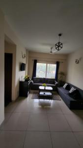 sala de estar con sofá y mesa en Vibe Villa, en Dehradun
