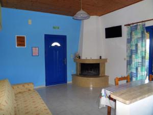 sala de estar con puerta azul y chimenea en Tentes Holiday Homes, en Vounaria