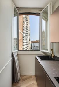 a kitchen with a window with a view of a building at Casa Duomo Monza - amazing cathedral view in Monza
