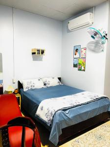 - une chambre avec un lit et une chaise rouge dans l'établissement MOCA MOTEL, à Cao Lãnh