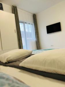 a bed with two pillows on it in a bedroom at Apartament zona de case-rezidențiala 2 km de Vivo Mall,curte privata in Baia Mare