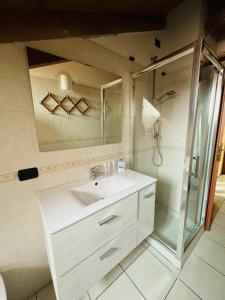 a bathroom with a white sink and a shower at La casa di Vale in Arona