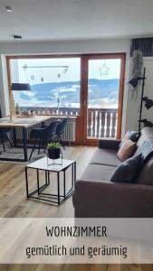 a living room with a couch and a table at Ferienwohnung Bergzeit mit Pool und Sauna in Missen-Wilhams