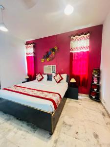 a bedroom with a large bed with pink walls at Hotel R S Royal Inn - kalka ji in New Delhi