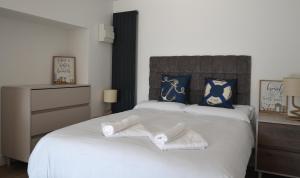 a bedroom with a large white bed with towels on it at Swn Y Mor - Sound of the Sea - by Aberporth Beach Holidays in Aberporth
