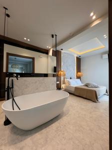 a large bathroom with a tub and a bed at Poema Antiparos in Antiparos