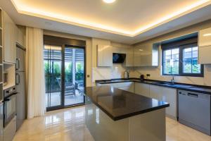 a large kitchen with white cabinets and black countertops at Villa Tutar 1 Marmaris Daily Weekly Rentals in Muğla