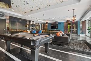 a billiard room with a pool table and a couch at CozySuites Mill District pool gym # 02 in Minneapolis