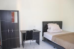 a bedroom with a bed and a dresser and a desk at Griya Mozaik in Jimbaran
