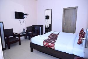 una camera con letto, scrivania e specchio di Hotel City Grand Varanasi a Varanasi