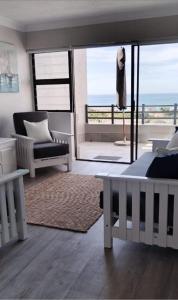 a bedroom with a bed and a view of the ocean at De Valle 37 in Mossel Bay