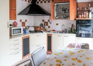cocina con mesa y fogones horno superior en Appartamento tranquillo a 10 minuti da Padova en Sarmeola