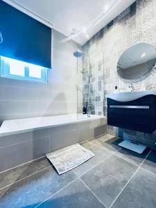 a bathroom with a tub and a sink and a mirror at Brand New St. Julian's Luxury Apartment - Wish Malta in St. Julianʼs