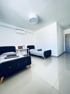 Habitación blanca con 2 camas y mesa en Brand New St. Julian's Luxury Apartment - Wish Malta en St Julian's