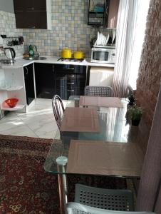 a kitchen with a glass table and chairs in it at Apartment on 8 Marta in Mykolaiv