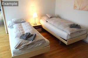 2 Betten in einem Zimmer mit Handtüchern darauf in der Unterkunft Residenz Senevita Westside in Bern