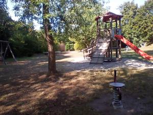 a playground with a red slide in a park at Ferienapartment Schlummerhausen in Beilstein +5 photos