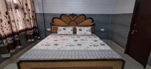 - un lit avec une tête de lit en bois dans l'établissement Cozy Retreat, à Haridwar
