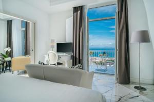 a hotel room with a bed and a view of the ocean at Palazzo Murrano - Adults Only in Vico Equense