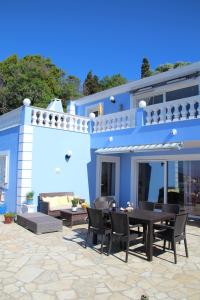 a blue house with a table and chairs in front of it at Villa Bettina 2nd floor in Afionas