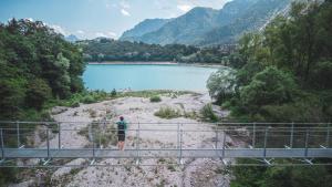 una persona in piedi su un ponte sopra un lago di Agritur Calvola a Tenno