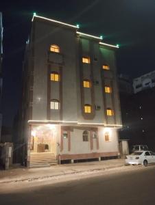 a tall building with lights on top of it at night at دار الرضا Dar Al Reda in Al Madinah