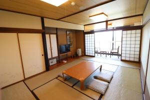 Habitación vacía con mesa y TV en Tokachi Makubetsu Onsen Grandvrio Hotel en Obihiro