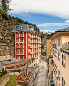 ein rotes Gebäude mitten in einer Stadt in der Unterkunft Hotel Eden Rock in Bad Gastein