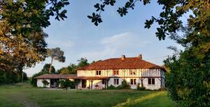 a large white house with a thatched roof at Xibouette in Lesgor